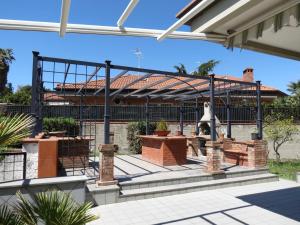 a pergola with benches and tables on a patio at Villa Ara Dell'Etna in Pedara