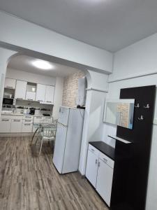 a kitchen with a white refrigerator and a table at Sejur la mare in Mangalia
