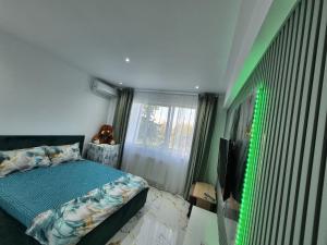 a bedroom with a bed and a flat screen tv at Sejur la mare in Mangalia