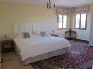 a bedroom with a large white bed with two pillows at Le Manoir Monlezun in Monlezun