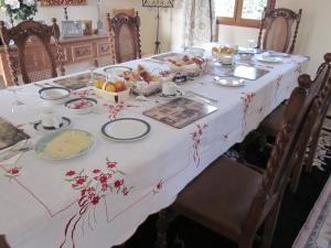 a table with a white table cloth with food on it at Le Manoir Monlezun in Monlezun