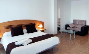 a bedroom with a large bed and a chair at Plaza de la Luz Cádiz in Cádiz