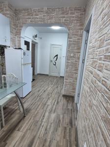 an empty room with a brick wall and a white refrigerator at Sejur la mare in Mangalia