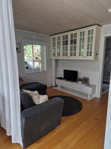 a living room with a couch and a tv at Skärgårdsidyll på Björkö med gångavstånd till havet in Skarvik