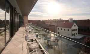 a balcony with tables and chairs on a building at Aminess Florian & Godler Hotel in Karlovac