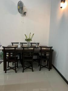 a dining room table with chairs and a vase of flowers at Cactus Piliyandala in Piliyandala