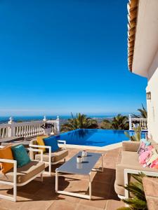 a patio with chairs and a table and a pool at Villa Mañana in Mijas