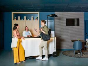 a man and a woman standing at a counter at Aparthotel Adagio Access La Défense Puteaux in Puteaux