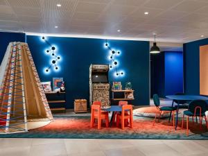 a room with a blue wall with tables and chairs at Aparthotel Adagio Access La Défense Puteaux in Puteaux +61 photos