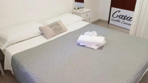 a white bed with towels on top of it at GuestHouse Gentile Caruso in Torrenova