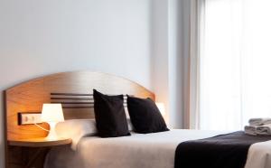 a bedroom with a bed with a wooden headboard at Plaza de la Luz Cádiz in Cádiz