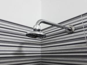 a light on a striped shower curtain at GuestHouse Gentile Caruso in Torrenova
