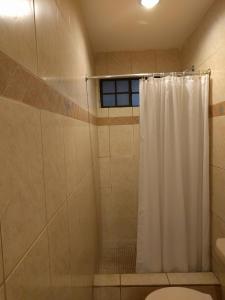 a bathroom with a shower with a shower curtain at Hotel El Almendro in Managua