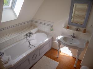 a white bathroom with a tub and a sink at La Ferme de la Sensée in Gouy-sous-Bellonne