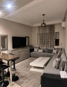 a living room with a couch and a flat screen tv at Parc app in Mohammedia