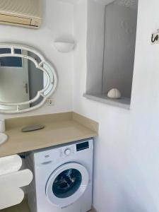 a washing machine in a bathroom with a mirror at Maria Elena - Suite Home in Mikonos