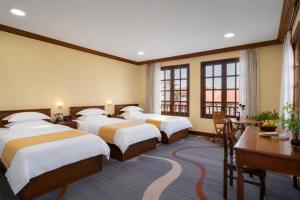a hotel room with four beds and a desk at Domi Hotel in Siem Reap +61 photos
