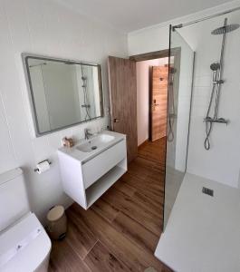 a white bathroom with a sink and a shower at Hotel Playa de Los Locos in Suances