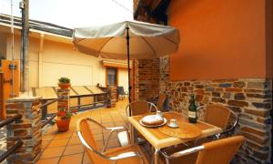 a table and chairs with an umbrella on a patio at El Cuelebre in Arancedo