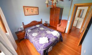a bedroom with a bed and a chair in it at El Cuelebre in Arancedo