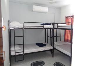 a room with three bunk beds in a room at Urban Hostels in Tiruvannāmalai