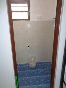 a small bathroom with a blue tile floor and a window at Urban Hostels in Tiruvannāmalai