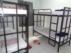 a room with three bunk beds in a room at Urban Hostels in Tiruvannāmalai +8 photos