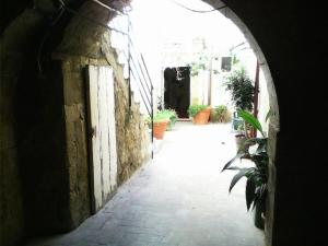 an archway leading into an alley with potted plants at Lungomare Elio Vittorini in Siracusa