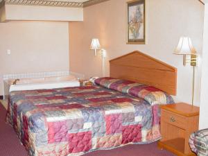 a hotel room with a bed and a bath tub at Garden Inn & Suites in Rockmart