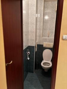 a bathroom with a toilet in a stall at Голям двустаен апартамент in Burgas