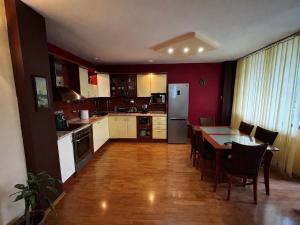 a kitchen with a table and chairs and a kitchen with a table and a kitchen at Голям двустаен апартамент in Burgas