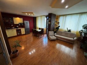 a living room with a couch and a table at Голям двустаен апартамент in Burgas