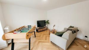 a living room with a table and a couch at Ô Cœur d'Objat - Baby-foot - Clim in Objat