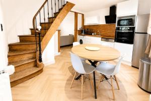 a kitchen and dining room with a wooden table and chairs at Ô Cœur d'Objat - Baby-foot - Clim in Objat +3 photos