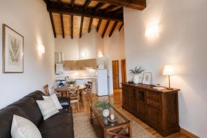 a living room with a black couch and a kitchen at Apartamento La Castañera in Colombres +4 photos