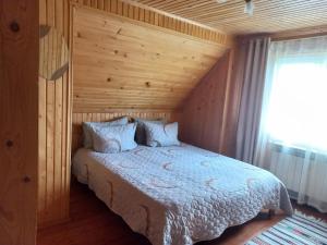 a bedroom with a bed with a wooden wall at Yaremche Potik Guest House in Yaremche