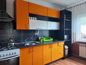 a kitchen with orange cabinets and a sink at Yaremche Potik Guest House in Yaremche