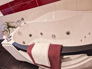 a white bath tub with a towel on it at JM Swiss Space Hostel in Langrickenbach