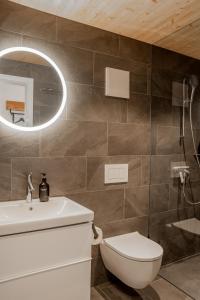 ein Badezimmer mit Toilette, Waschbecken und Spiegel in der Unterkunft Studio Lago in Tüscherz-Alfermée + 14 Fotos