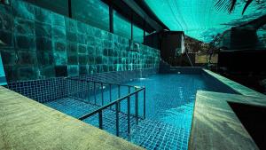 a swimming pool with blue lights in a building at Hillora Coastal Resort Goa in Arpora