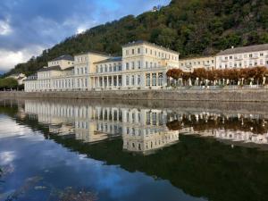 a large white building next to a body of water at Ferienwohnung im roten Haus, die Therme ist fußläufig in 350m zu erreichen in Bad Ems