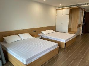 a bedroom with two beds and a cabinet at L'Azur Cửa Lò in Cửa Lô +8 photos