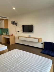 a room with a bed and a tv on a wall at L'Azur Cửa Lò in Cửa Lô