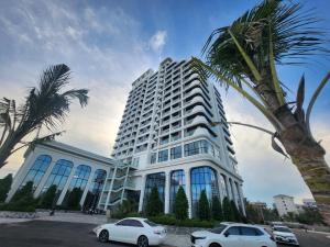 a large white building with cars parked in front of it at L'Azur Cửa Lò in Cửa Lô
