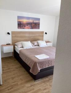 a bedroom with a large bed with a wooden floor at Apartments SKY in Brela