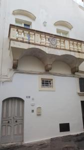 a white building with a balcony and a door at Domus Dejana in Gallipoli +15 photos