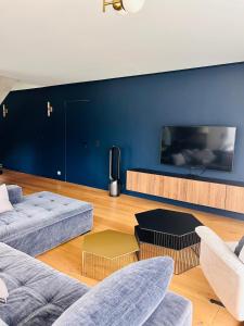 a living room with two couches and a flat screen tv at Villa premium avec extérieur ensoleillé in Urrugne