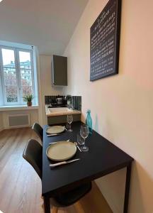 a black table with two chairs and a chalkboard at Joyau historique 101 in Aurillac +3 photos