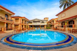 a large swimming pool in a courtyard of a house at Resort Terra Paraiso Goa - A Beach Property in Calangute