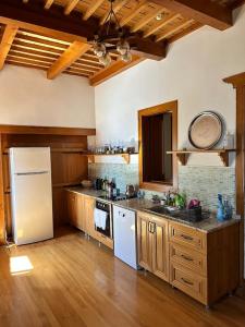 a kitchen with a white refrigerator and wooden cabinets at Villa Historyka in Alanya